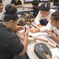 Irene assists BGCAS Music Club members learn how to string their ukuleles.