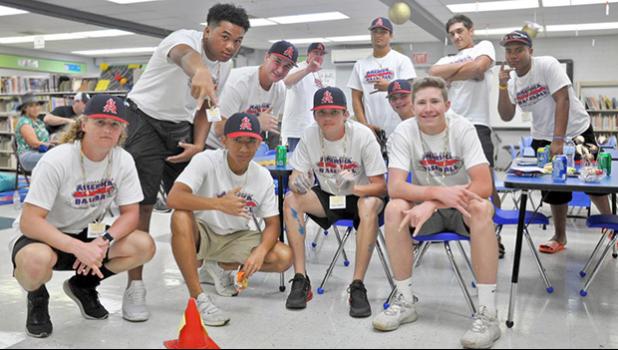 Members of the 18U Amerika Samoa National Baseball team post inside the library at Juan M. Guerrero Elementary school with the 5 Star Legacy National Baseball Team.