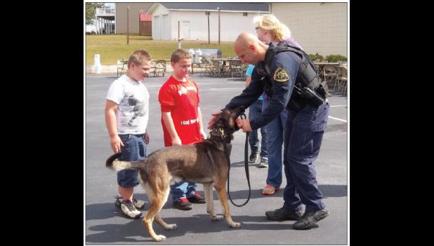 Thomas Robertson (left) and Brandon Burrows (left center) watch as the K-9 Unit practices commands at the First Responders Appreciation Day last Saturday.