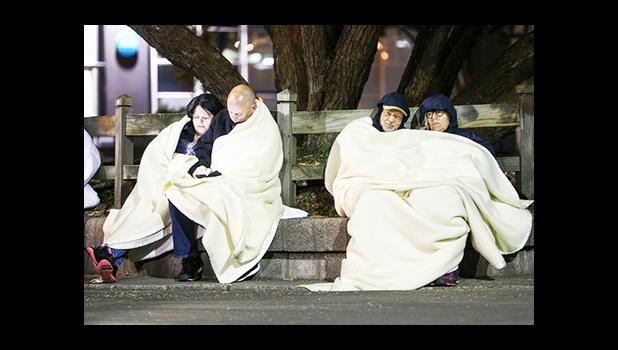 Evacuated hotel guests gather in a carpark in Wellington. [Photograph: Hagen Hopkins/Getty Images]