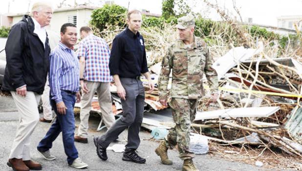  President Trump walks with FEMA administrator Brock Long (second from right) and Lt. Gen. Jeff Buchanan (right) as he tours an area affected by Hurricane Maria in Guaynabo, Puerto Rico, on Oct. 3. [Evan Vucci / AP]