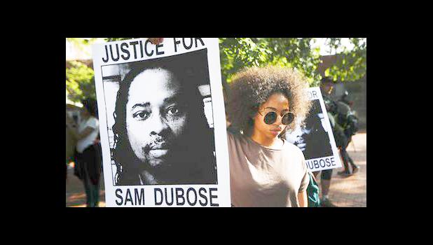 In this June 28, 2017, file photo, protesters holds signs as they gather for a demonstration on the University of Cincinnati campus demanding that a white former police officer be tried a third time in the fatal shooting of an unarmed black motorist in Cincinnati. As cities and towns host July 4th parades and fireworks shows, some minority residents are expressing mixed feelings about the holiday used to reaffirm the country's founding based on equality and civil liberties. (AP Photo/John Minchillo, File) In this June 28, 2017, file photo, protesters holds signs as they gather for a demonstration on the University of Cincinnati campus demanding that a white former police officer be tried a third time in the fatal shooting of an unarmed black motorist in Cincinnati. As cities and towns host July 4th parades and fireworks shows, some minority residents are expressing mixed feelings about the holiday used to reaffirm the country's founding based on equality and civil liberties. (AP Photo/John Minchillo, File)