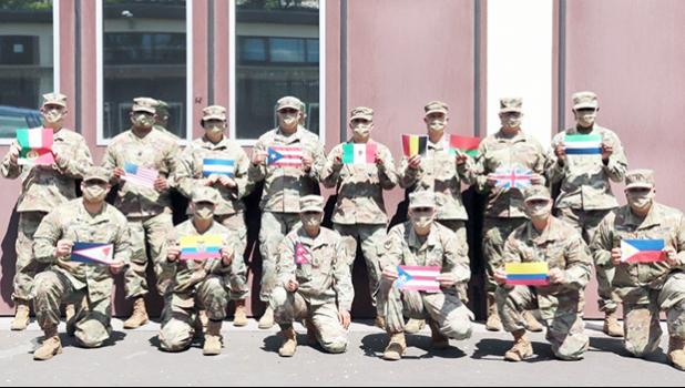 Diverse members of 773rd Civil Support Team, wih flags of their countries of origin.