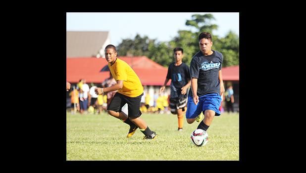 A Iakina Adventist Academy player dribbles by a Samoa Baptist opponent of the Boys Grades 6-8 division on Match Day 2 of the 2016 FFAS Private Elementary Schools soccer league at the Kanana Fou Seminary Field on Thursday, Oct. 20, 2016.  [FFAS MEDIA/Brian Vitolio]