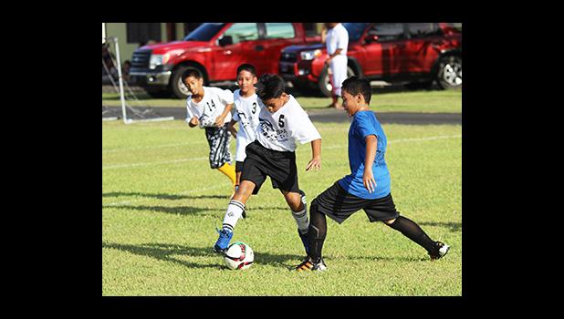 An SPA player, left and a St. Theresa opponent of the Boys 3-5 bracket in action during Match Day 2 of the 2016 FFAS Private Elementary Schools soccer league at the Kanana Fou Seminary Field on Thursday, Oct. 20, 2016.   [FFAS MEDIA/Brian Vitolio]