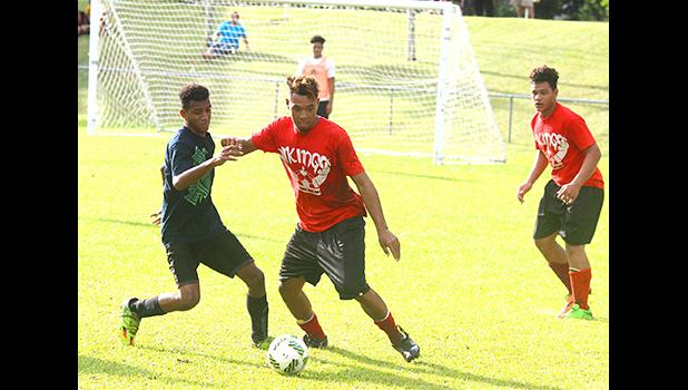 Steven Fiso, right, of the Fag’a’itua Vikings varsity team holds off an Iakina Saints opponent during an ASHSAA Boys varsity Soccer game on Wednesday, April 4, 2018 at Pago Park Soccer Stadium.  [FFAS MEDIA/Brian Vitolio]