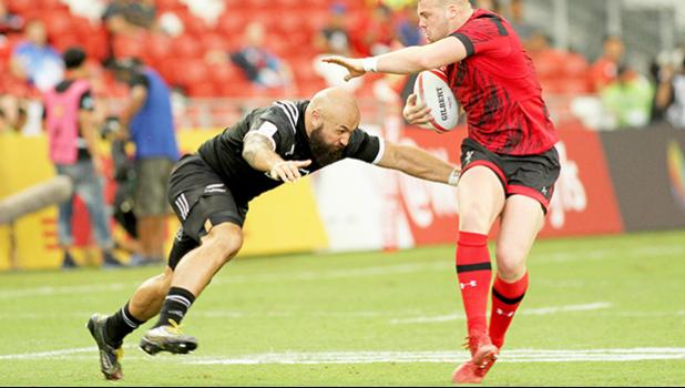 NZ Joe Ravouvou plays with a Wales defender as he scores a try in the All Blacks 36-14 victory over Wales at the Singapore Sevens, Day 1, National Stadium, Singapore. [Photo: Barry Markowitz]