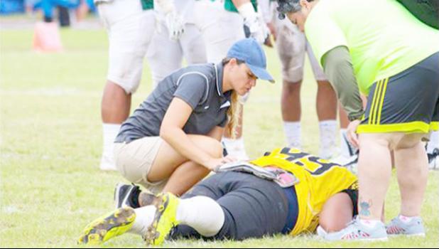 American Samoa’s only Certified Athletic Trainer Florence Wasko attended the IOC World Conference last week for an update on the latest within the field of sports medicine. She works for ASDOE — Athletic Division — and is seen here during a local football game treating a player who was injured during play.  [SN file photo]