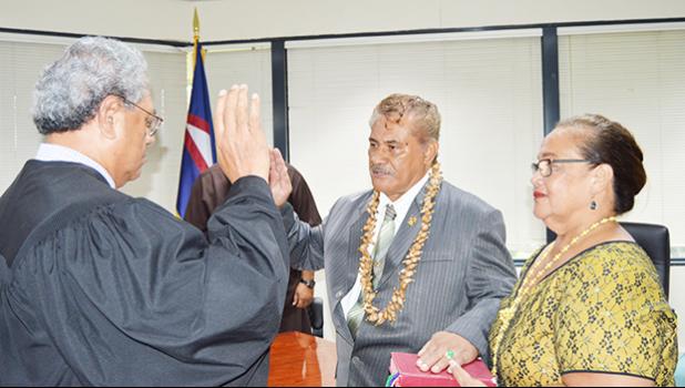 Associate Judge Suapaia Pereira (far left) administers the oath of office for the new Western District Governor, Fuamatu J.V. Fuamatu, (middle) at the Governor’s Office Conference Room yesterday morning. Holding the Bible is Fuamatu’s wife. [photo: AF]