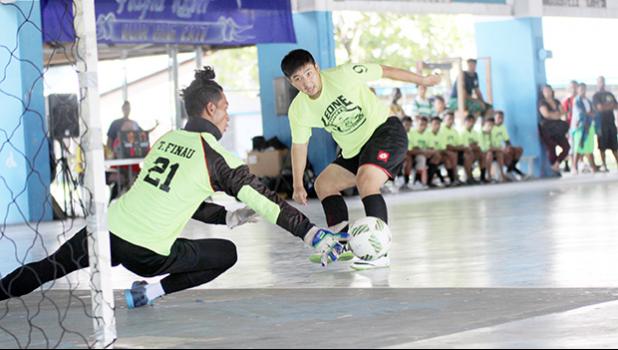 Gun Kang (#9) of Ilaoa & To’omata watches his shot being deflected by Vaiala Tongan goalkeeper Kinikinilau Pouli during their 2017 Futsal Tournament’s pool game at Samoana High School’s gymnasium on Saturday, May 6, 2017.  [FFAS MEDIA/Brian Vitolio]