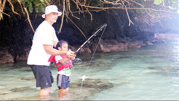 One of the youngest participants in this year's Sanctuary Summer Science in the Village (SSSV) program, learning how to properly use a fishing pole during one of four Tautai Fagota Fishing Derbies  hosted by the NMSAS and local sponsor SOPAC/Aloha Maid.  [photo: BC]