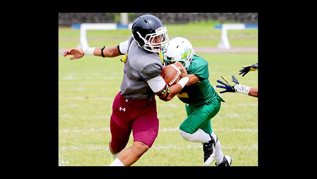 Panama Filoiali’i, top scorer for the Tafuna Warriors in their match against the Lions – trying to balance out as he is pushed by a Leone defender during their JV showdown this past Saturday. The Warriors won by 50 - 18. [photo: TG]
