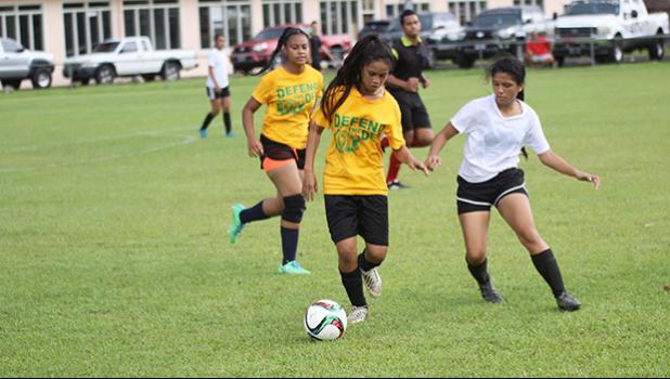 Ama Faleao of Leone tries to dribble away from Maricar Parungo of the Fa’asao Cougars during an ASHSAA varsity girls’ soccer game on Saturday, Feb. 24, 2018 at Pago Park Soccer Stadium.  [FFAS MEDIA/Brian Vitolio]