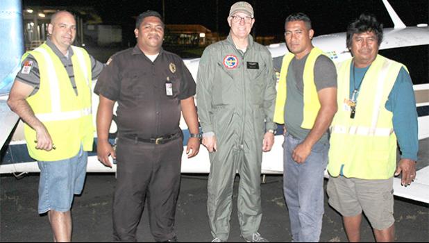 Texan aviator and pilot Brian Lloyd (middle) on the tarmac at the Pago Pago International Airport, with people who serviced his plane last Saturday night, upon arrival for a stopover in American Samoa, around 9 p.m. Lloyd is on an around-the-world solo flight to commemorate American female aviator, Amelia Earhart’s famous flight 80-years ago. Pictured with him (L-R) Jason Pritchard of Pritchard’s Airport Service — a local airport ground handling company — an airport police officer, and the PAS crew. [photo: