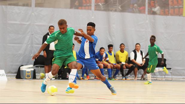 American Samoa’s Henry Milo Tiatia gets physical on the ball with a Solomon Islands’ opponent during a game of the OFC Youth Futsal Tournament at Bruce Pulman Arena in Auckland, New Zealand on Wednesday, October 4, 2017.  [FFAS MEDIA/Brian Vitolio]
