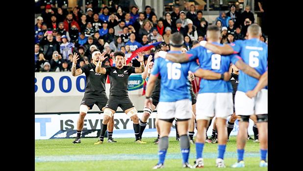 With Samoa flags to their back, the NZ All Blacks respond to Samoa's Siva Tau with their legendary Haka.  The New Zealand All Blacks defeated Manu Samoa 15s 78-0 at Eden Park, Auckland, New Zealand.   [Photo: Barry Markowitz]
