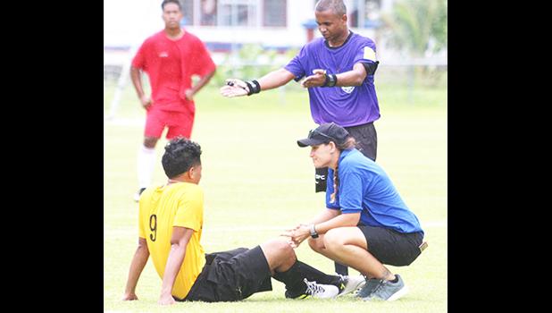 ATC Florence Wasko tending to an injured Paul Collins from the Pago Youth team during an injury time-out early in the opening half of their match up against Veitongo FC last Saturday afternoon. Pago Youth tied the team from Tonga 1 - 1. [photo: TG]