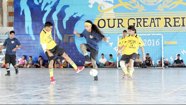 A Pago Youth 2 player and Vaitogi United opponent in action during their 2017 Futsal Tournament’s pool game at Samoana High School’s gymnasium on Saturday, May 6, 2017.  [FFAS MEDIA/Brian Vitolio]