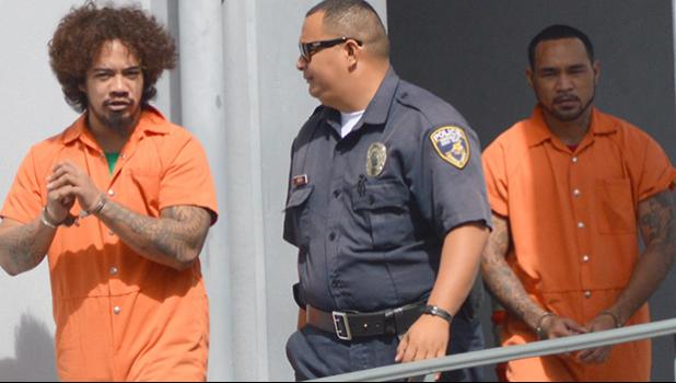 DPS police officer escorting prison escapees Joseph Iosefa Iakopo and Ryan Pite outside the District Court after their initial appearance yesterday morning.  [photo: AF]