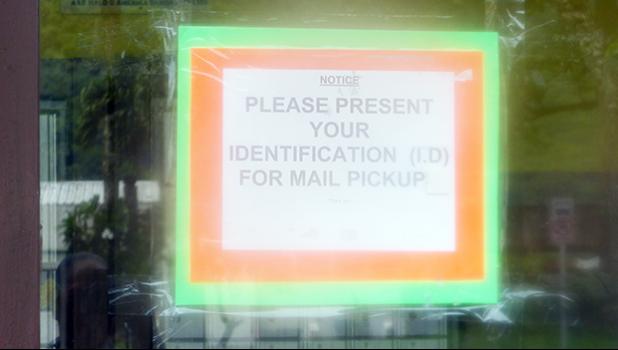 A sign at the local US Post Office in Fagatogo informing people picking up their mail that an ID is now needed. However, Samoa News understands the policy is for parcel pickup, not for mail inside PO boxes.   [photo: Leua Aiono-Frost]