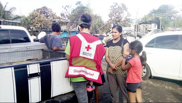 Local American Red Cross Disaster Team member Fa’asaei Davenport speaking with members of a family in Ili’ili, who lost their home in an Aug. 28 fire. Remnants of the burnt home are seen behind the family members. Five different fires displaced 5 families — with their homes a total loss, during the last week of August. The Red Cross depends on public donations from the community to help those in need; and Red Cross donation boxes can be found on the check out counters of many retail stores in the territory.