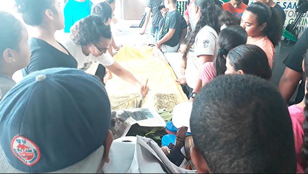 Local artist Reggie Meredith-Fitiao showing kids from the FIT summer program, how to 'elei using 'ulu leaves, fala, and potato stamps. [Courtesy photo]