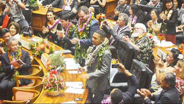 Hawai’i state Rep. Cedric Solosolo Asuega Gates (standing-front) being recognized along with another lawmaker, on the floor of the Hawai’i state House of Representatives on Jan. 18 — the opening of the Hawai’i Legislature. Family members of lawmakers were also on the floor behind them.  [photo: Rep. Gates Office]