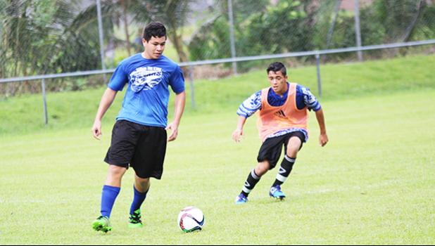 Samoana’s Joseph Choi Jr. looks to cross the ball as a Kanana Fou opponent looks on during their ASHSAA Boys’ varsity soccer playoff game on April 29, 2017 at Pago Park Soccer Stadium. The Sharks won 1-0.  [FFAS MEDIA/Brian Vitolio]