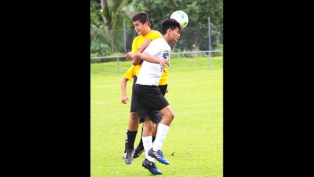 A Samoana Sharks player heads the ball forward while being contested in the air by a Tafuna Warriors’ opponent during an ASHSAA Boys’ JV soccer game on Tuesday, March 27, 2018 at Pago Park Soccer Stadium.  [FFAS MEDIA/Brian Vitolio]
