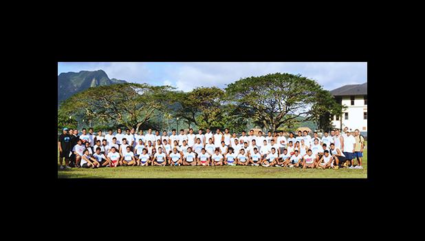 Samoana High School – "Home of the Sharks" Football Program, both the Varsity and Junior Varsity put together, alongside Head Coach Pati Pati (far right) and his coaching staff, at the conclusion of practice yesterday evening at their school field. The Sharks will be making their initial appearance for the season in their match up against the Warriors tomorrow afternoon. “Shark Up Go Blue” says Pati to supporters. [photo: TG].