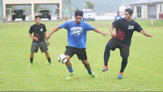 Ueli Tualaulelei, left, tries to control the ball while being defended by Iakina’s Kato Lasalo during their ASHSAA Boys semifinal game on Tuesday at Pago Park Soccer Stadium.   [FFAS MEDIA/Brian Vitolio]