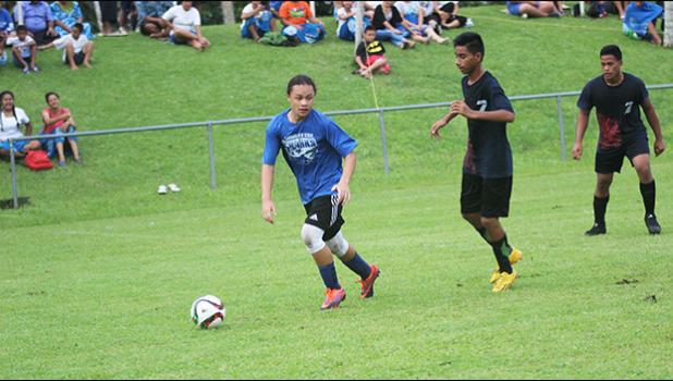 Samoana Sharks’ varsity player Gabriel Taumua dribbles away from a Iakina player during their ASHSAA Boys semifinal game on Tuesday at Pago Park Soccer Stadium.   [FFAS MEDIA/Brian Vitolio]