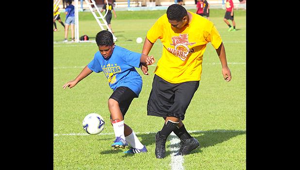 Aaron Singh, left, of the Fa’asao-Marist Crusaders dribbles the ball against a Tafuna Warriors opponent during an ASHSAA Boys J-V Soccer game on Monday, April 2, 2018 at Pago Park Soccer Stadium.  [FFAS MEDIA/Brian Vitolio]
