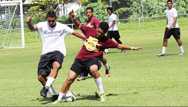 A Crusaders player (left), and Warriors opponent battle for control of the ball during their ASHSAA Boys’ varsity soccer playoff game on Saturday, April 29, 2017 at Pago Park Soccer Stadium.  [FFAS MEDIA/Brian Vitolio]