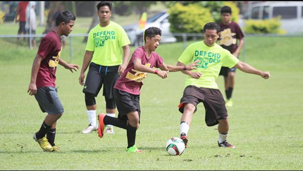 A Tafuna player tries to dribble past a Leone defender during their ASHSAA Boys’ J-V soccer playoff game on April 29, 2017 at Pago Park Soccer Stadium. Tafuna won 1-0.  [FFAS MEDIA/Brian Vitolio]