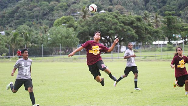 A Tafuna Warriors’ player heads the ball away from SPA’s Peter Reid during their ASHSAA Boys semifinal game this past Tuesday at Pago Park Soccer Stadium.  [FFAS MEDIA/Brian Vitolio]