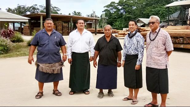This undated photo provided by ASG Commerce Department, shows DOC director Keniseli Lafaele (far right), next to him is Paul Young, ASPA’s Managing Director and the Governor’s Tongan Liaison Officer, Sione Lousiale Lotolua Kava (far left) and officials of the Tonga Forestry and Milling Company in Tonga. In the background (on the right side) are electricity poles manufactured by the Tonga Forestry and Milling Company.  [photo: provided by DOC]