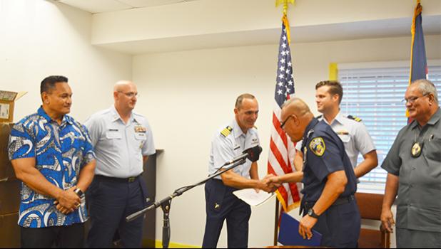 Falana’ipupu Taase Sagapolutele shaking hands with U.S Coast Guard Sector Commander from Honolulu, Capt. Michael C. Long after the DPS Deputy Commissioner received his Certificate of Recognition last week. See story for details.  [photo: AF] 