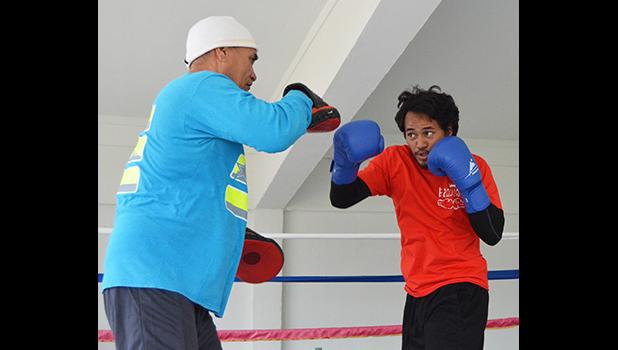 Trainer, Sala Senele Etuale hitting the pad with one of the local boxers 