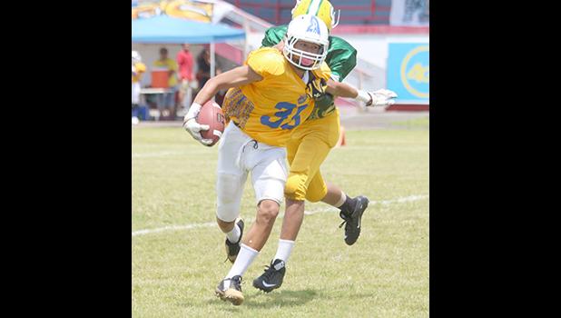 Sam Mikaele of the AYFS Rams trying to evade a tackle from a Packers defender during their season opener last Saturday at the Veterans Memorial Stadium. Mikaele scored the two point conversion that put the Rams over the Packers, 8-6 [photo: TG]
