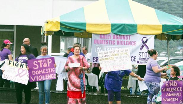 Amata and other rally participants holding signs