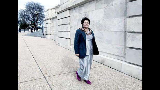 Amata outside in Washington D.C. walking toward her office building.