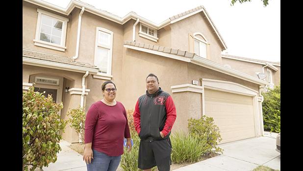 Makerita Iosefo-Va'a and her husband Shaun Va'a pose in front of a relative's home