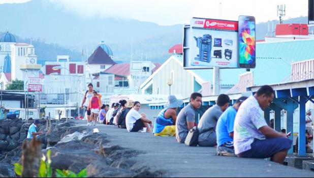 Samoa residents sit along the seawall in downtown Apia