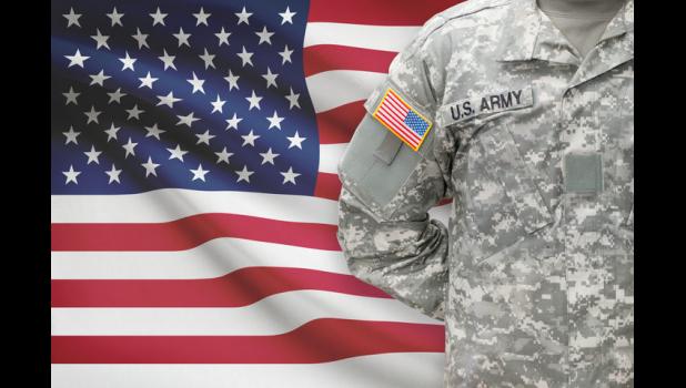 Solier standing in front of American flag.