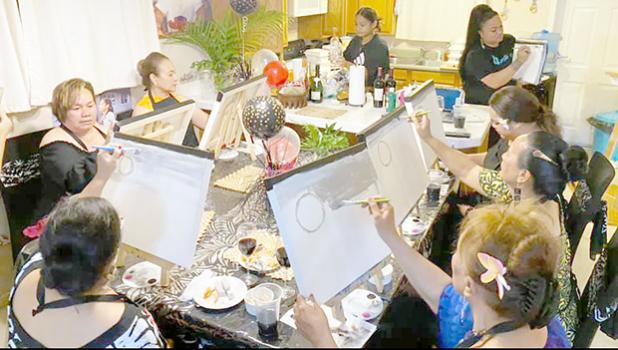 Women painting sitting around a large table