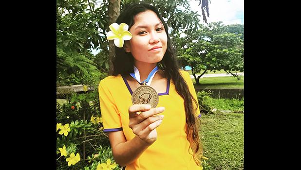 Miss Trish Buenavista, president of the Phi Theta Kappa (PTK) honor society chapter at ASCC, displays her PTK medallion. She has recently been chosen by the PTK administration to serve as a regional officer, which will involve organizational duties for regional PTK events. (Read story inside for details. Trish Buenavista HOLDING ptk MEDAL
