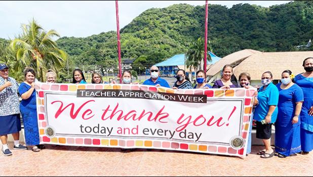 DOE admin holding up Teacher Appreciation Week banner
