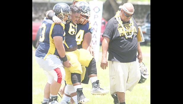 An injured Nu’uuli Wildcat offensive lineman is carried off the field by his teammates, a protocol established by ATC Florence Wasko throughout the season.  [photo: TG]