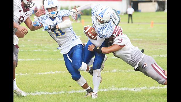 Kalisi Lotulelei of Samoana is stopped by Tafuna's middle linebacker at the line of scrimmage during the opening quarter of their varsity championship game last Saturday morning. Lotulelei helped the Sharks to a 7-6 victory over Tafuna. [photo: TG]